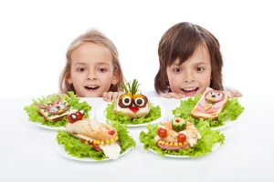 Kids discovering the the healthy sandwich alternative - creative food creatures on plates